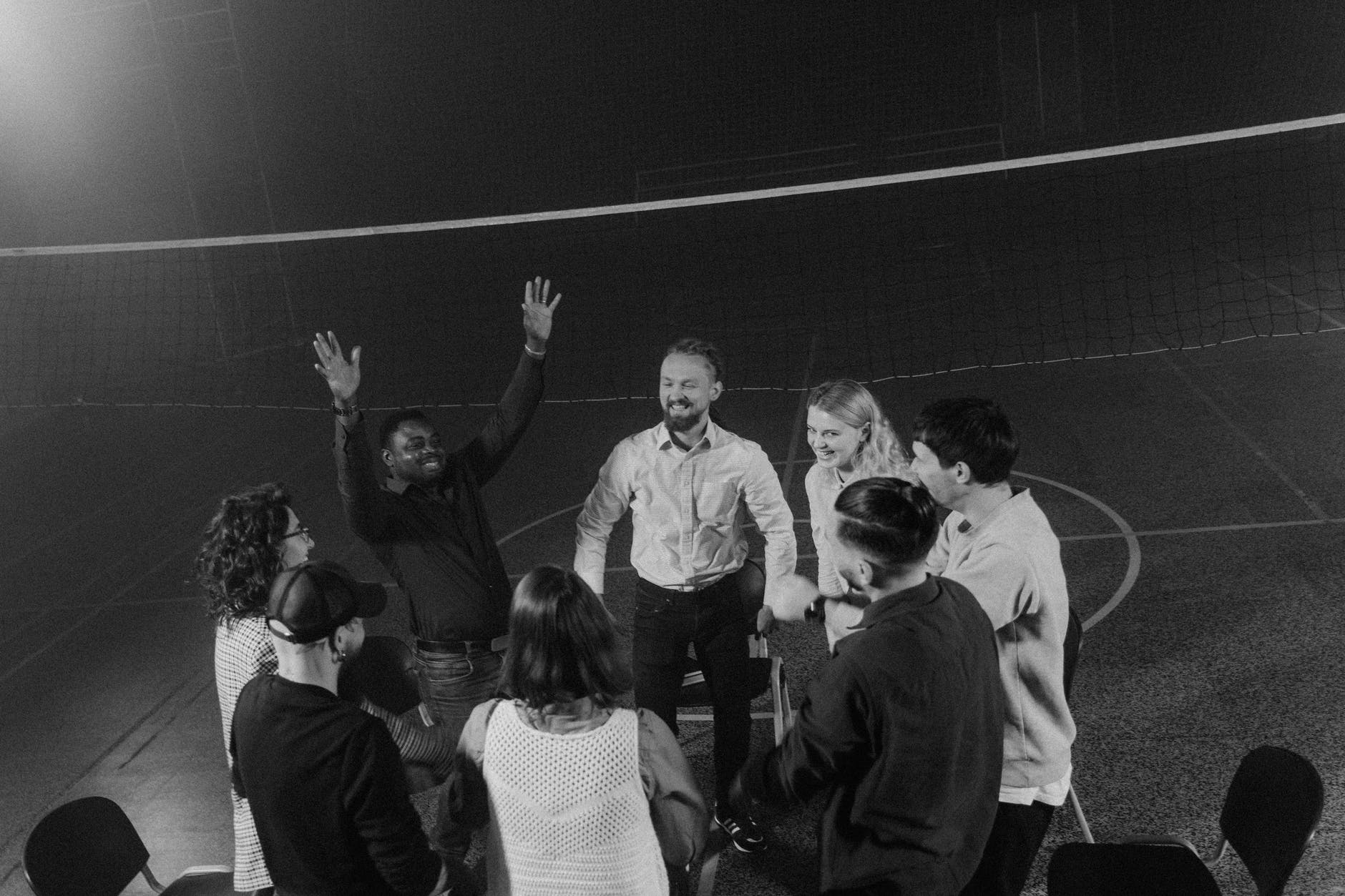 Small group in a gymnasium, man with hands raised